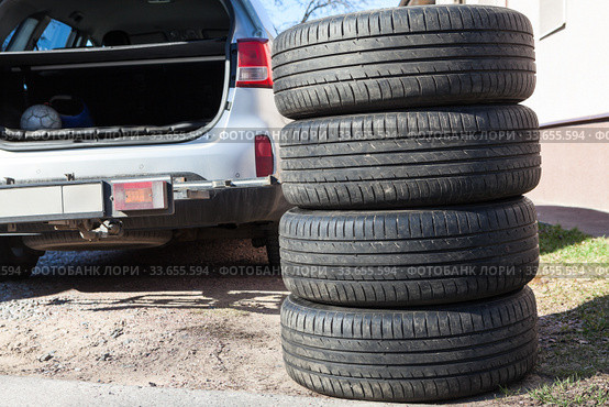 Four summer tyres are next to opened trunk of suv car, seasonal tire change. Стоковое фото, фотограф Кекяляйнен Андрей / Фотобанк Лори