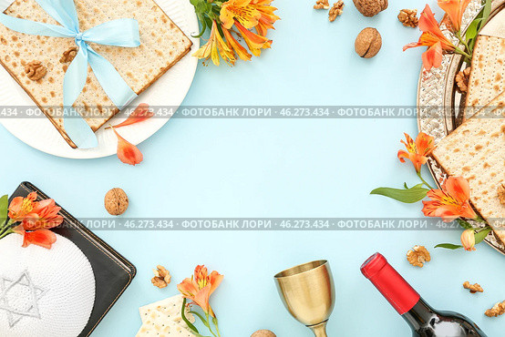 Frame made of flatbread matza, wine, Torah, kippah and alstroemeria flowers on color background. Стоковое фото, фотограф Pixel_shot / Фотобанк Лори