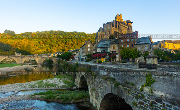 French township of Estaing on bank of Lot River with arched bridge and fortified castle. Стоковое фото, фотограф Яков Филимонов / Фотобанк Лори