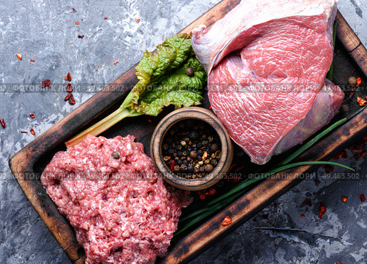 Fresh raw beef on cutting board and peppercorn. Beef and forcemeat. Стоковое фото, агентство Ingram Publishing / Фотобанк Лори