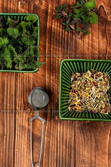 Fresh young nettle and a tea spoon on rustic wooden table. Herbal medicine, homeopathy. Urtica dioica, stinging nettle.. Herbal tea with stinging nettle. Стоковое фото, агентство Ingram Publishing / Фотобанк Лори
