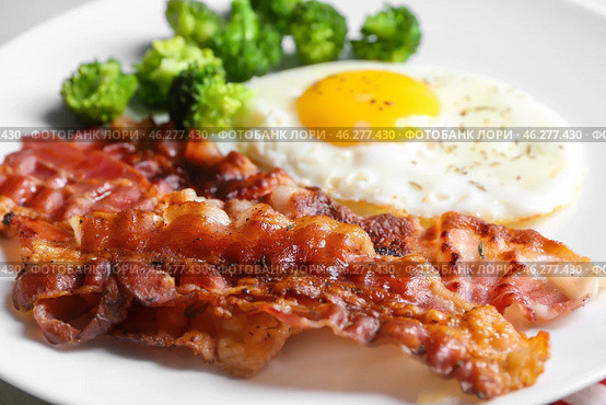 Fried bacon rashers and egg on plate, closeup. Стоковое фото, фотограф Pixel_shot / Фотобанк Лори