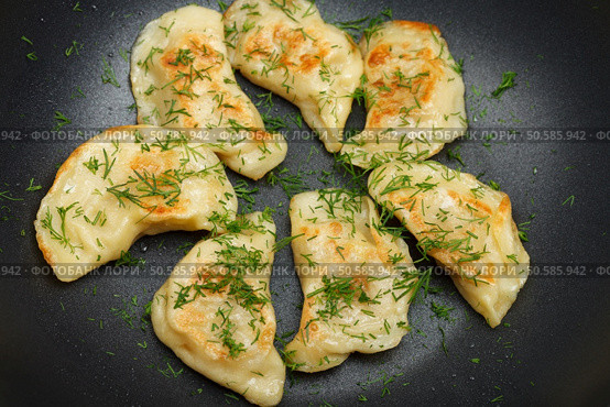 Fried dumplings with fresh dill and drops of oil. Top view, low aperture shot, focus on the front side. Стоковое фото, агентство Ingram Publishing / Фотобанк Лори