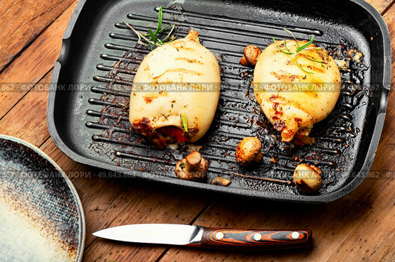 Fried squid stuffed with mushrooms on grill pan. Tasty roast squid with vegetable stuffing. Стоковое фото, агентство Ingram Publishing / Фотобанк Лори