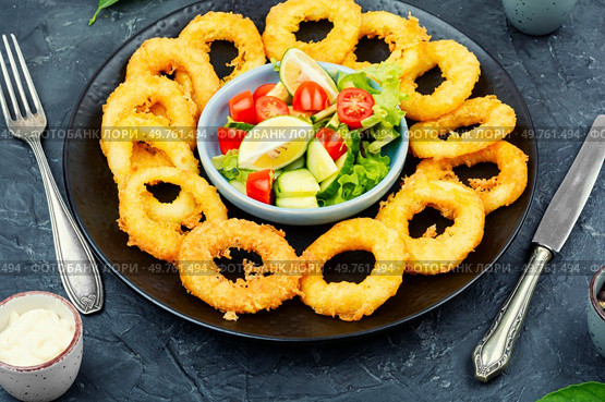Fried squids or octopus (calamari) with fresh vegetable salad.. Battered squid rings,seafood. Стоковое фото, агентство Ingram Publishing / Фотобанк Лори
