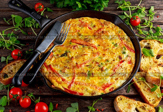 Frittata made of eggs, potato, bacon, paprika, parsley, green peas, onion in iron pan. on wooden table. Frittata made of eggs, potato, bacon, paprika, parsley, green peas, onion, cheese in iron pan. on wooden table. Стоковое фото, агентство Ingram Publishing / Фотобанк Лори