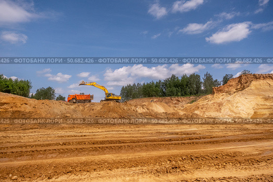 From afar - the work of a sand quarry. There is a lot of equipment, the development of minerals is underway. Стоковое фото, фотограф Дина Дамоцева / Фотобанк Лори