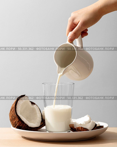 front view hand pouring coconut milk glass. High resolution photo. front view hand pouring coconut milk glass. High quality photo. Стоковое фото, агентство Ingram Publishing / Фотобанк Лори