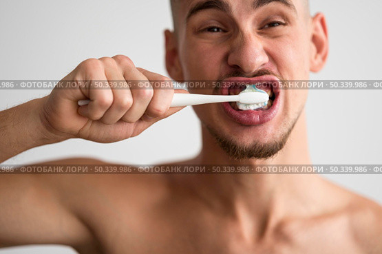 front view man brushing his teeth morning. Стоковое фото, агентство Ingram Publishing / Фотобанк Лори