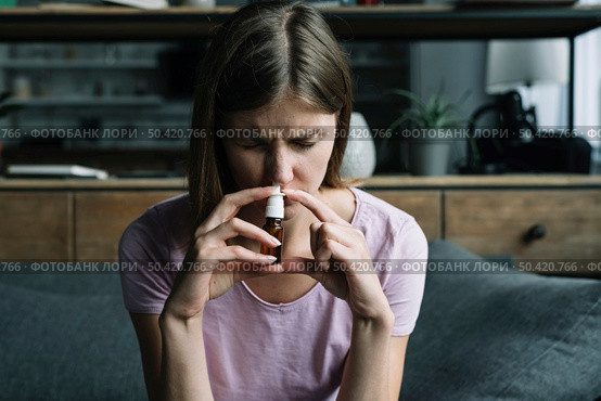 front view sick woman sniffing nasal spray. Стоковое фото, агентство Ingram Publishing / Фотобанк Лори