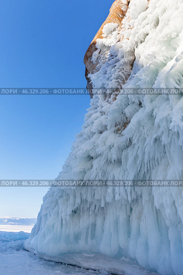 Frozen Baikal Lake. Amazing natural texture with bizarre icicles on ice crust of famous Cape Sagan-Khushun or Three Brothers Rocks. Unusual winter landscape. Natural landmark of Olkhon Island. Стоковое фото, фотограф Виктория Катьянова / Фотобанк Лори