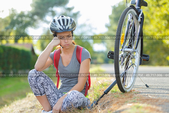 frustrated female cyclist has a puncture. Стоковое фото, агентство Ingram Publishing / Фотобанк Лори