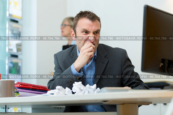 frustrated man sat at computer with screwed up paper balls. Стоковое фото, агентство Ingram Publishing / Фотобанк Лори