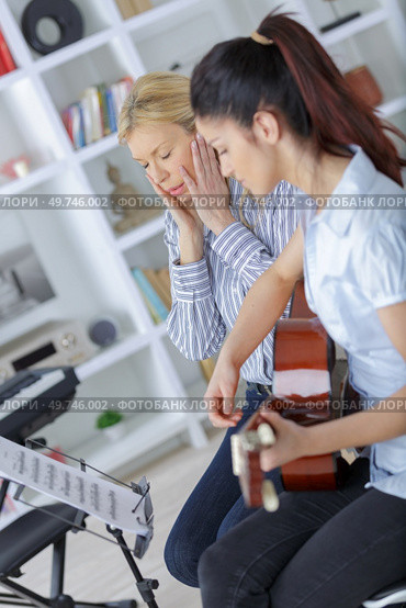 frustrated teacher teaching the spanish guitar. Стоковое фото, агентство Ingram Publishing / Фотобанк Лори