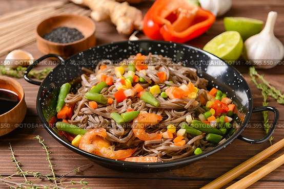 Frying pan with tasty soba noodles and shrimps on wooden background. Стоковое фото, фотограф Pixel_shot / Фотобанк Лори