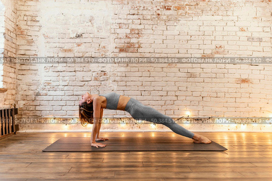 full shot senior woman stretching indoors. Стоковое фото, агентство Ingram Publishing / Фотобанк Лори