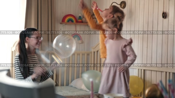 Fun Kids Celebration with Colorful Balloons, Party Horn Blowers and Festive Hats. Joyful Siblings Children Playful Little Girls and a Boy Dancing, Jumping, Playing among Golden Decorations. Party Time. Стоковое видео, видеограф Марина Демидюк / Фотобанк Лори