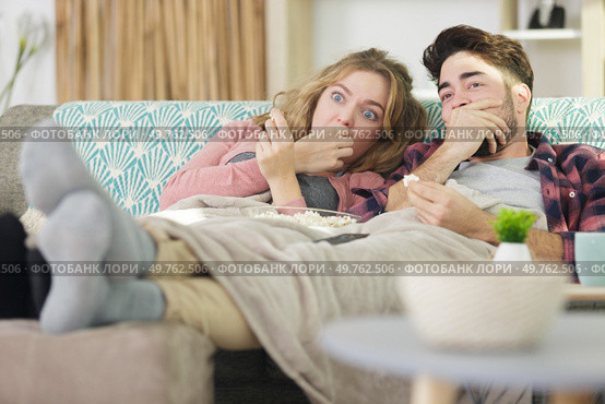 funny couple watching horror movie. Стоковое фото, агентство Ingram Publishing / Фотобанк Лори