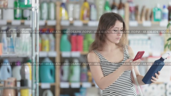 Girl buyer scans qr code on tile cleaner spay label. Стоковое видео, видеограф Яков Филимонов / Фотобанк Лори