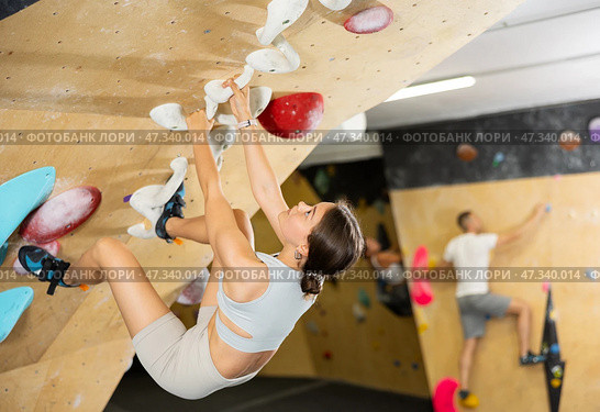 Girl conquering inverted bouldering wall at climbing gym. Стоковое фото, фотограф Яков Филимонов / Фотобанк Лори