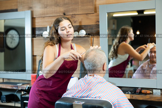 Girl master hairdresser completes creation of senior male clients image with help of scissors. Стоковое фото, фотограф Яков Филимонов / Фотобанк Лори
