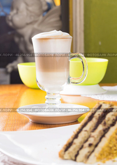 Glass cup of layered coffee latte on table. Стоковое фото, фотограф Сергей Толмачёв / Фотобанк Лори
