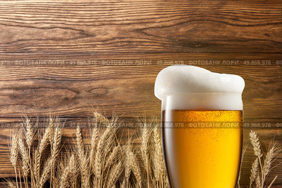 Glass of beer with wheat on wooden background. Стоковое фото, агентство Ingram Publishing / Фотобанк Лори