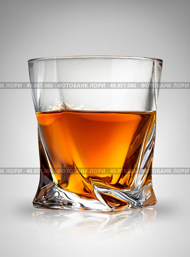 Glass of cognac on a gray background. Стоковое фото, агентство Ingram Publishing / Фотобанк Лори