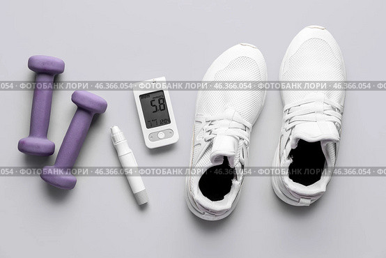 Glucometer, sneakers, lancet and dumbbells on grey background. Diabetes concept. Стоковое фото, фотограф Pixel_shot / Фотобанк Лори
