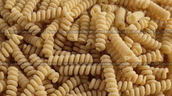 Gluten Free Cornmeal Pasta Wallpaper. Spiral Raw Macaroni from Corn and Rice flour rotating on Turntable. Close Up Top View. Uncooked Pasta Spinning. Full Frame. Food Background. Fusilli Bucati Corti. Стоковое видео, видеограф Марина Демидюк / Фотобанк Лори