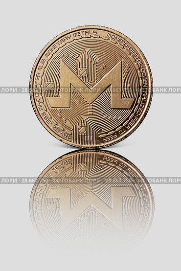 Gold Monero coin is reflected on a white glossy background. Modern way of exchange. Стоковое фото, фотограф Ярослав Данильченко / Фотобанк Лори