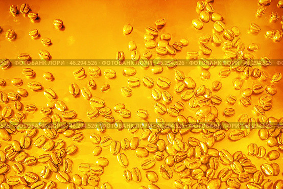 Golden Coffee Beans Scatter Beautifully on a Rich Amber Surface, Creating a Stunning Visual. Coffee beans on a golden yellow expensive background texture. Стоковое фото, фотограф Владимир Разгуляев / Фотобанк Лори