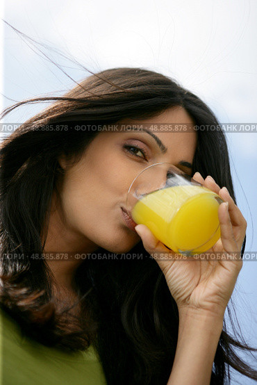 Gorgeous woman drinking orange juice. Стоковое фото, агентство Ingram Publishing / Фотобанк Лори