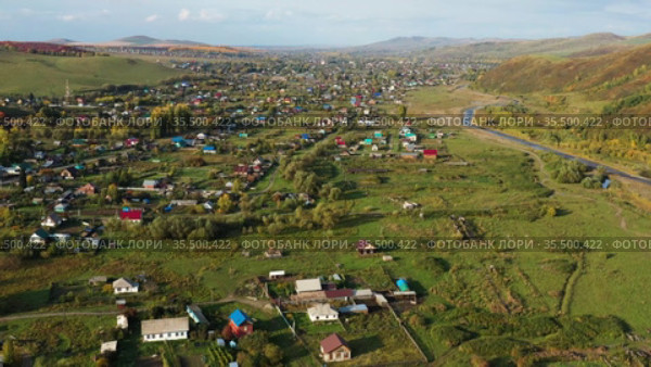 Горный Алтай осенью. Село Алтайское. Окрестности курорта Белокуриха. Вид с высоты птичьего полета. Altai mountains in autumn. Altayskoye village. Surroundings of Belokurikha resort. Aerial view. (2020 год). Стоковое видео, видеограф Евгений Романов / Фотобанк Лори