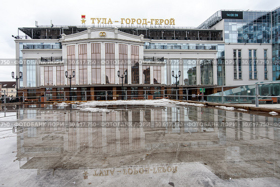 Город Тула. Здание торгового центра "Гостиный двор" зимним днём на фоне облачного неба и его отражение в луже (2019 год). Редакционное фото, фотограф Игорь Низов / Фотобанк Лори