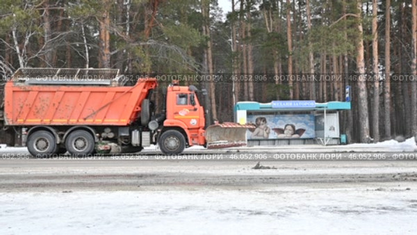 Город Заводоуковск. Автомобиль  обрабатывает дорогу от гололеда. Автобусная остановка "Механизаторов" Редакционное видео, видеограф Александр Тараканов / Фотобанк Лори