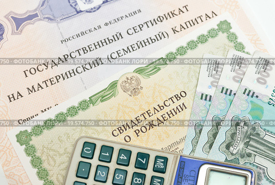 Государственный сертификат на материнский капитал, свидетельство о рождение, карманный калькулятор и российские рубли (2016 год). Редакционное фото, фотограф Игорь Низов / Фотобанк Лори