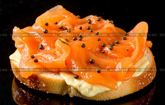 Gourmet appetizer with smoked salmon and cream cheese on toasted bread, delicious canape on black background for restaurant menu concepts. Стоковое AI-изображение, AI-художник Павел Муравьев / Фотобанк Лори