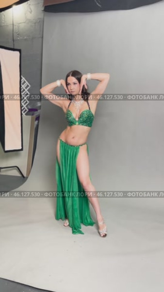 Graceful belly dance performance by a skilled dancer in a vibrant green costume. Стоковое видео, видеограф Гурьянов Андрей / Фотобанк Лори