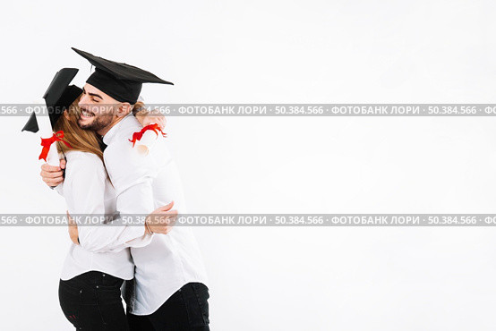 graduating couple embracing. Стоковое фото, агентство Ingram Publishing / Фотобанк Лори