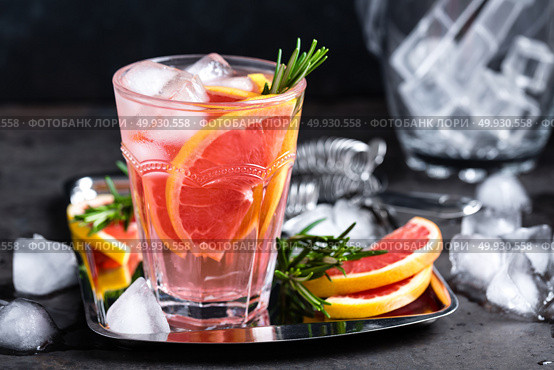 Grapefruit and fresh rosemary gin cocktail with juice, cold summer citrus refreshing drink or beverage with ice. Стоковое фото, агентство Ingram Publishing / Фотобанк Лори