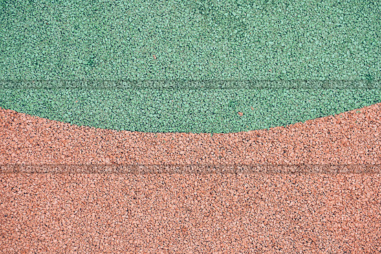 Green and orange rubber coating for playgrounds. EPDM rubber granules. Covering for sports and playgrounds. Rubber mulch for safety and injury prevention with copy space. Стоковое фото, фотограф Darya Komarova / Фотобанк Лори