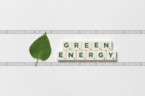 Green energy words formed of scrabble tiles with green tree leaf on white background. Nature and renewable energy concept.. Green energy formed of scrabble tiles with tree leaf. Стоковое фото, агентство Ingram Publishing / Фотобанк Лори