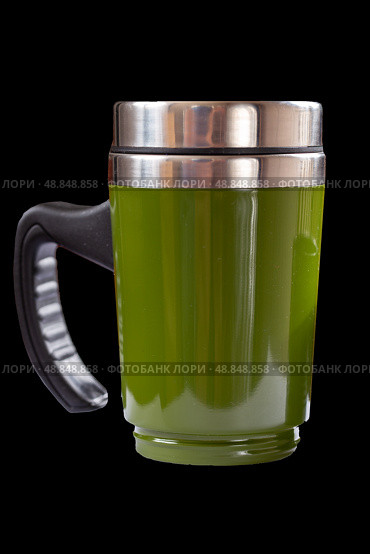 Green travel sippy thermal mug on black background. Стоковое фото, фотограф Евгений Ткачёв / Фотобанк Лори