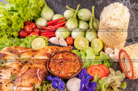 Grilled chicken on a plate with sticky rice, chilies, garlic sauce and sprinkled with pepper seeds. Стоковое фото, агентство Ingram Publishing / Фотобанк Лори