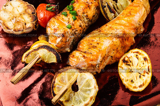Grilled fish, grilled salmon steak with addition of lemon.Closeup. Grilled salmon on skewer. Стоковое фото, агентство Ingram Publishing / Фотобанк Лори