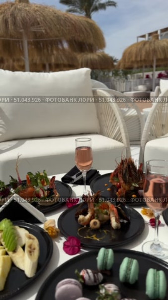 Grilled salmon steak with crispy skin sauteed vegetables and lemon served in outdoor restaurant in summer light A wooden table with a variety of dishes containing seafood, vegetables and fruit.Hand holding a spoon ready to eat pineapple fried rice with shrimp, served in a pineapple bowl, surrounded by fresh fruits and tea on a cozy table setting.Party Sea Food platter with salmon and prawns, low angle view, close-up Sea food party platter, extreme Whole poached salmon with cucumber slices for scales, high end party platter, overhead view Tiger prawns on the grill Macarooni cookies floating on blue background, levitation, macarooni cookies, dessert, sweets, colorful, delicious Two Glasses of Pink Champagne with Macarons and Oranges Elegant seaside celebration with seafood, pink floral decor, and sparkling wine overlooking the ocean. Стоковое видео, видеограф Zita Khasanova / Фотобанк Лори
