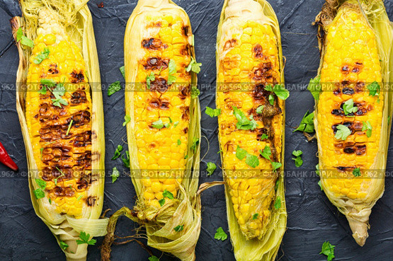 Grilled sweet corn with sauce and spicy.Summer vegan snack. Grilled corn cobs. Стоковое фото, агентство Ingram Publishing / Фотобанк Лори
