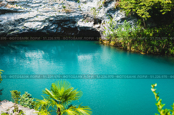 Grotto and blue clear mountain lake with vegetation along the banks. Стоковое фото, фотограф Елена Руй / Фотобанк Лори