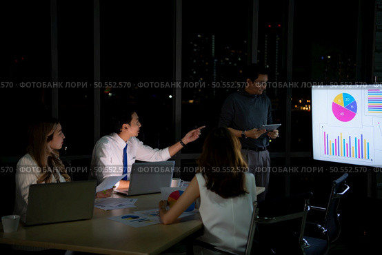 Group of broker international stock traders working actively at night in office, Everyone is striving for the team’s success. Стоковое фото, агентство Ingram Publishing / Фотобанк Лори
